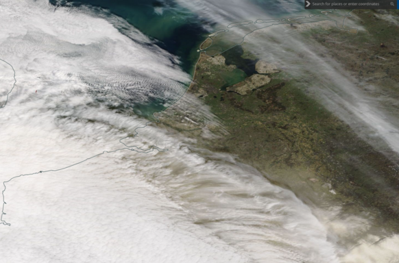 Foto gemaakt door NASA - Zo trokken zand en bewolking woensdag Nederland binnen. Duidelijk is te zien hoe de zon al snel geen kans meer maakte. 