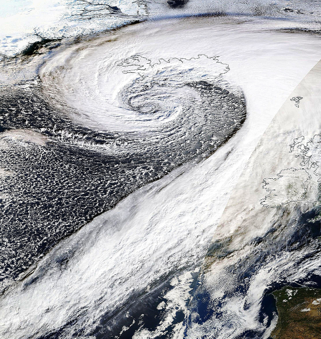 Foto gemaakt door NASA Worldview - Op satellietfoto's is de 'bomcycloon' als een grote krul te zien. In het midden, nabij IJsland, is de kerndruk het laagst Foto gemaakt door NASA Worldview - Op satellietfoto's is de 'bomcycloon' als een grote krul te zien. In het midden, nabij IJsland, is de kerndruk het laagst
