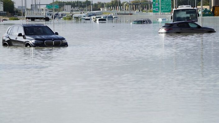 Achtergelaten auto's op een overstroomde straat in Dubai. Bron: AP Photo