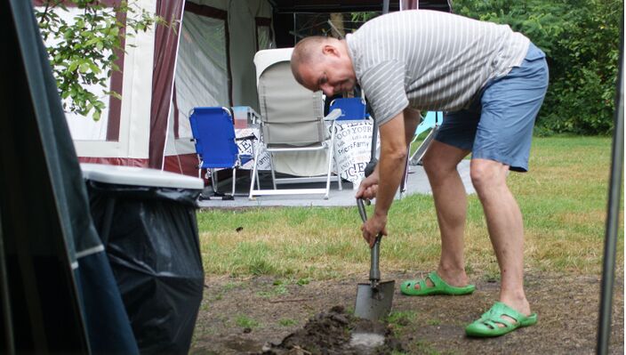 Foto gemaakt door Joost Mooij - Alphen aan den Rijn - Op de camping is het soms graven om het water weg te laten lopen en de tent droog te houden.