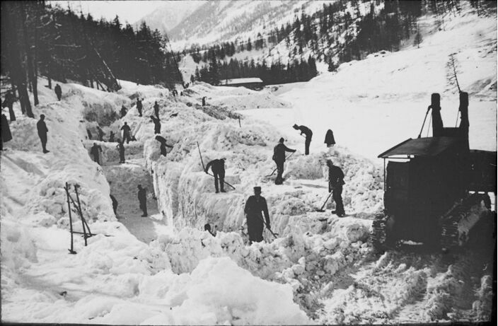 Foto gemaakt door ETH-Bibliothek - Punt Nova - Reddingswerkers zijn in januari 1951 bezig om de weg tussen Zernez en Brail van sneeuw te ontdoen 