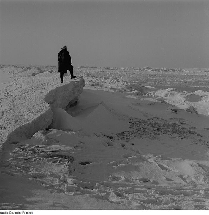 Foto gemaakt door Richard Peter - Rügen - Een wandelaar staat in de winter van 1963 op een ijsshots op het strand van het Duitse eiland Rügen. 